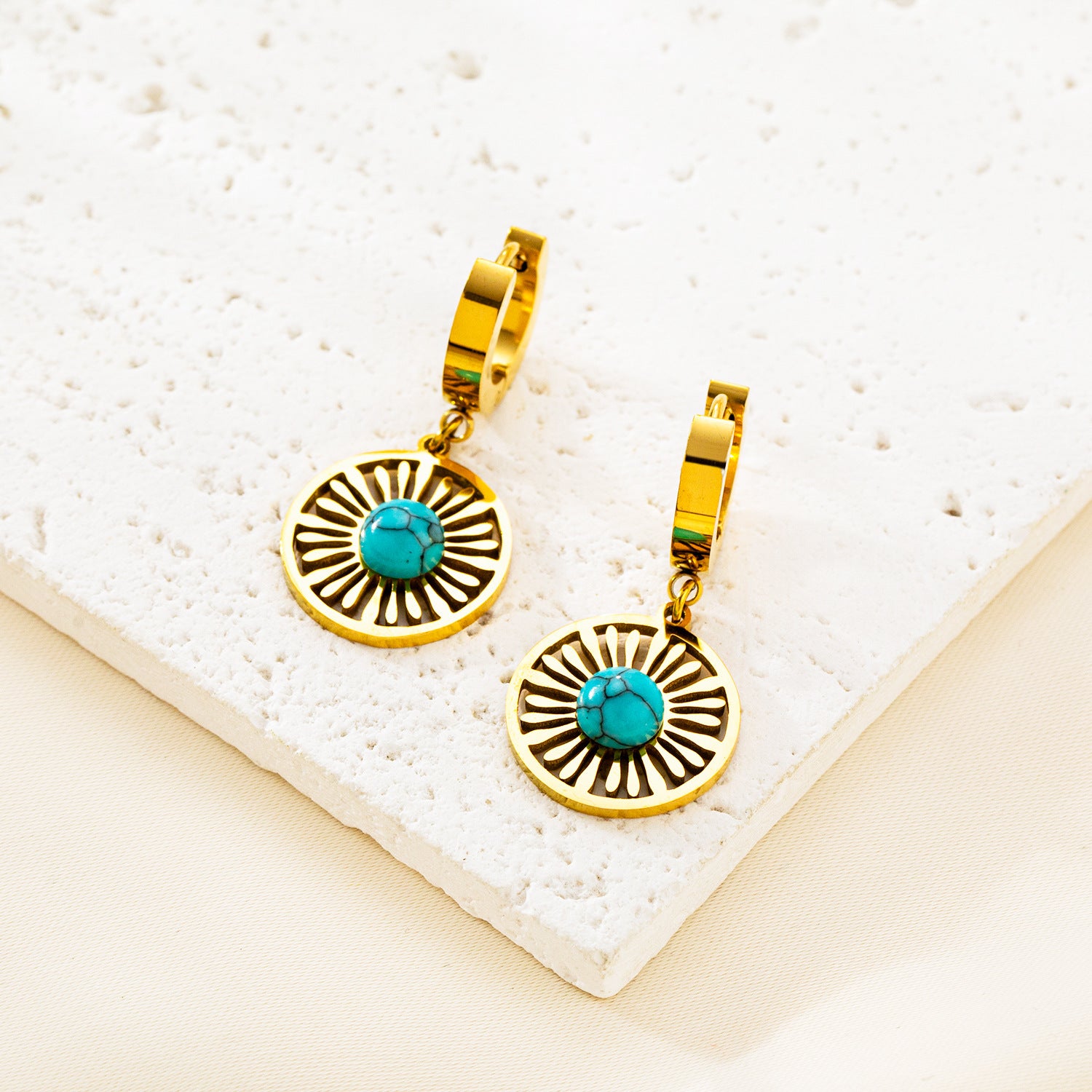 Gold plated stainless steel hoop earrings with round hollow geometric pendant, modern minimalist design for women.