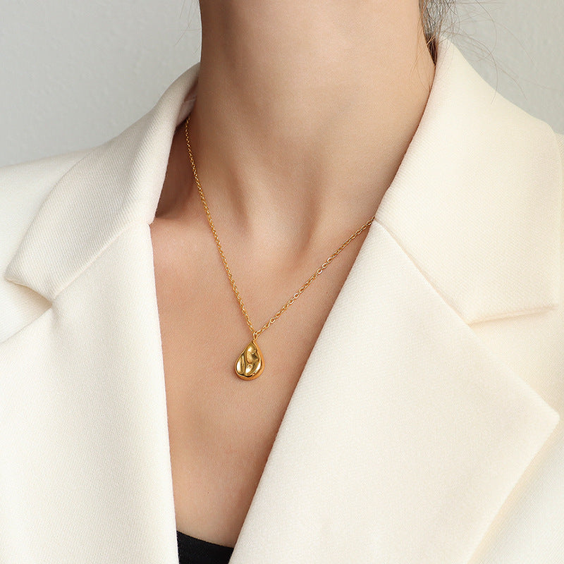 18K gold plated stainless steel water drop pendant necklace with concave geometric design and pearl accent, adjustable chain on white background