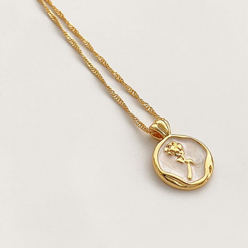 Gold PVD plated stainless steel necklace with round zircon flower pendant, minimalist floral design displayed on chain.