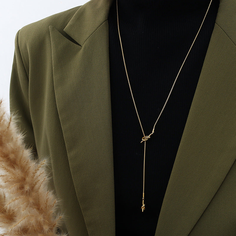 18K gold plated stainless steel knotted pendant necklace with long adjustable chain, geometric trendy women’s jewelry on white background