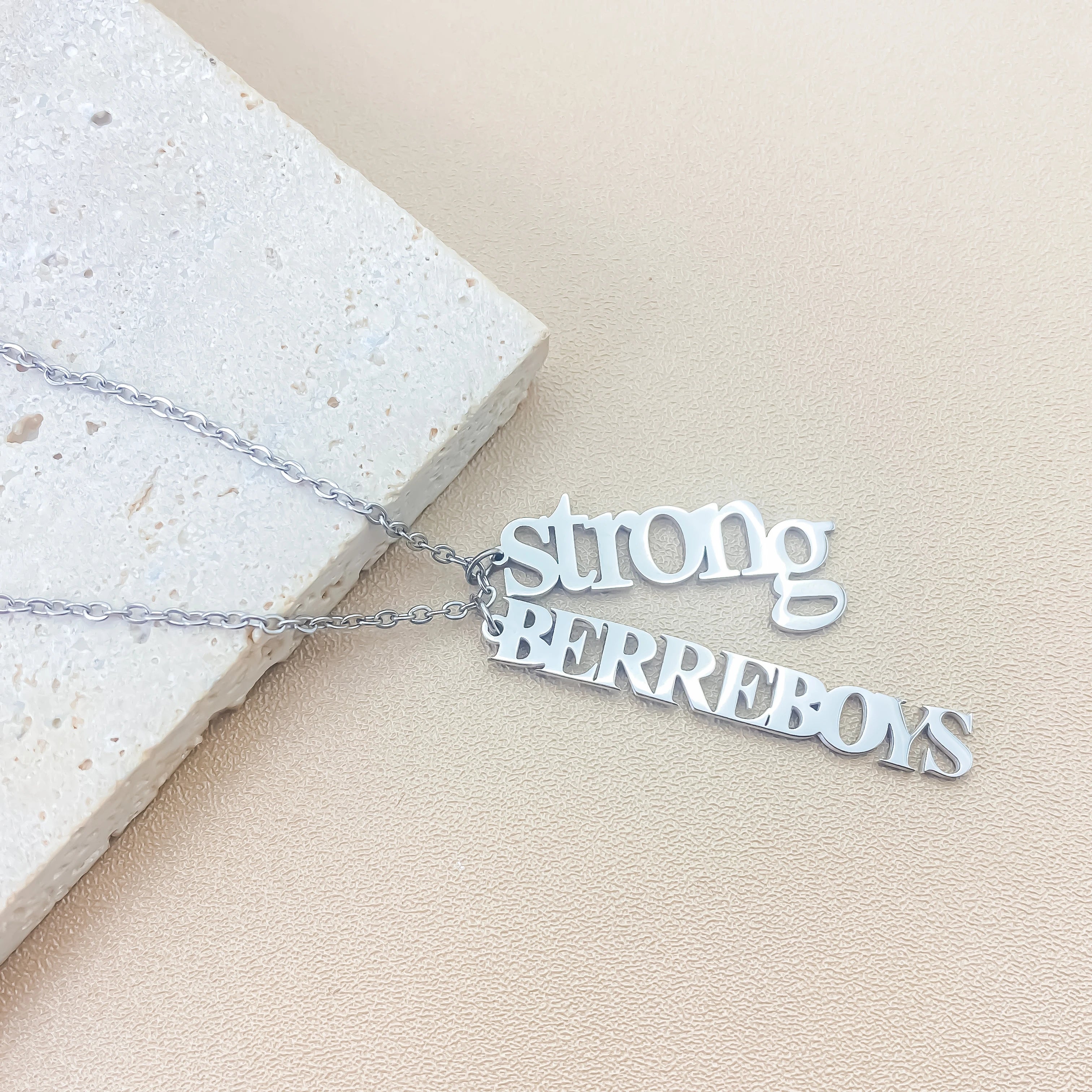 Personalized vertical name necklace in stainless steel with multiple custom name pendants, adjustable 40+5 cm chain, gold finish shown on model.