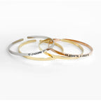 Minimalist 316L stainless steel engraved bar cuff bracelet with custom lettering, 4mm width, gold finish shown.