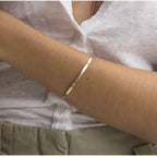 Minimalist 316L stainless steel engraved bar cuff bracelet with custom lettering, 4mm width, gold finish shown.