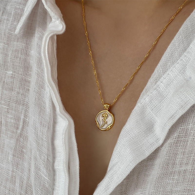 Gold PVD plated stainless steel necklace with round zircon flower pendant, minimalist floral design displayed on chain.