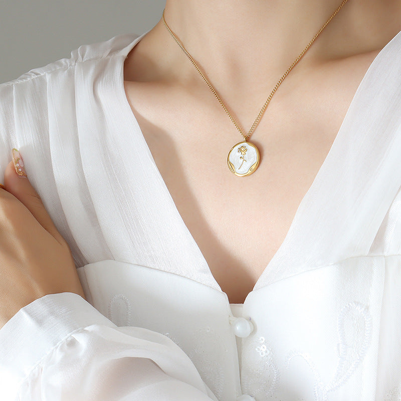 Gold PVD plated stainless steel necklace with round zircon flower pendant, minimalist floral design displayed on chain.