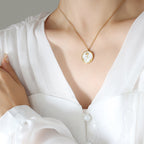 Gold PVD plated stainless steel necklace with round zircon flower pendant, minimalist floral design displayed on chain.