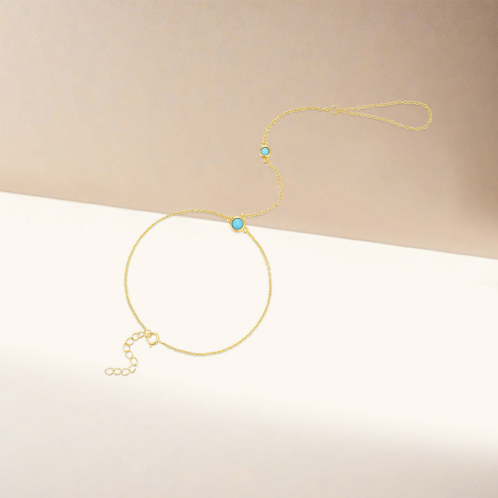 Gold plated 925 sterling silver hand chain bracelet with round turquoise stone and finger loop design