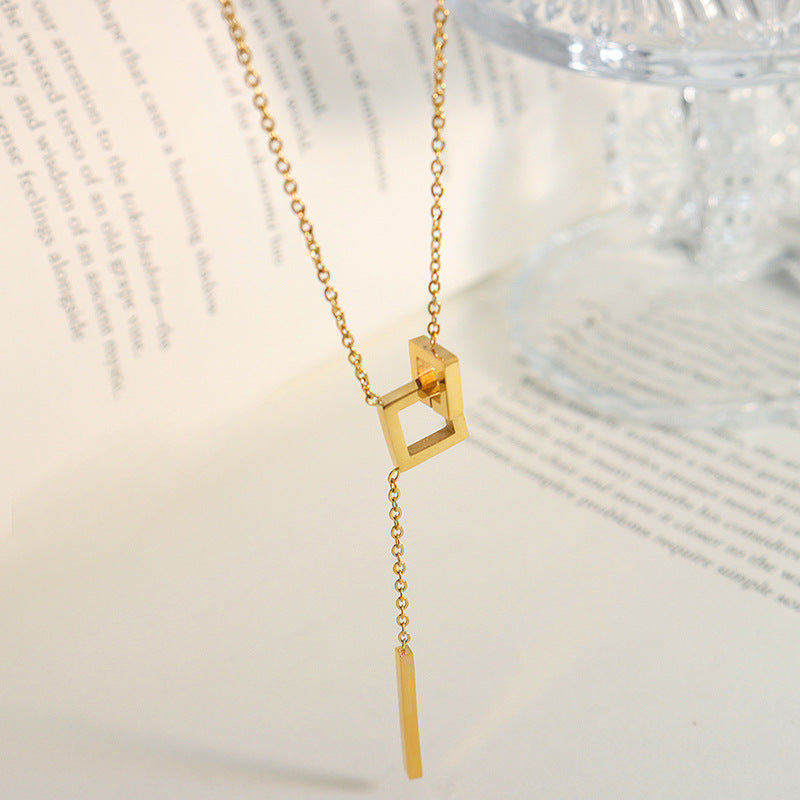 18K gold plated stainless steel geometric tassel pendant necklace with hollow square design and adjustable link chain on white background