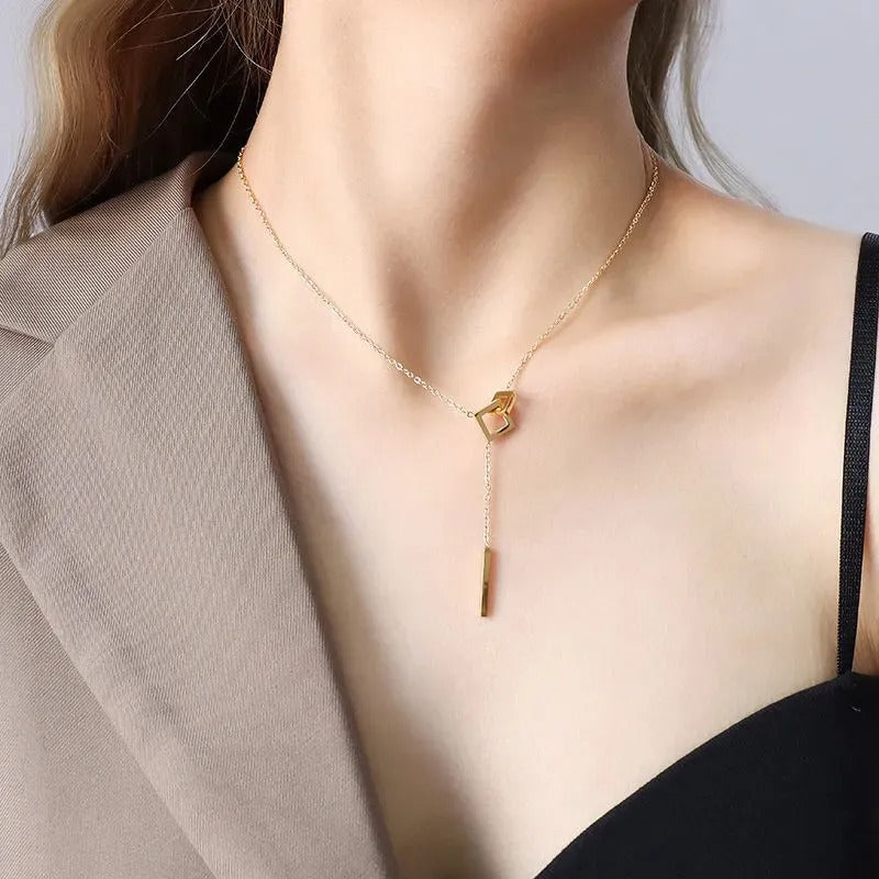 18K gold plated stainless steel geometric tassel pendant necklace with hollow square design and adjustable link chain on white background