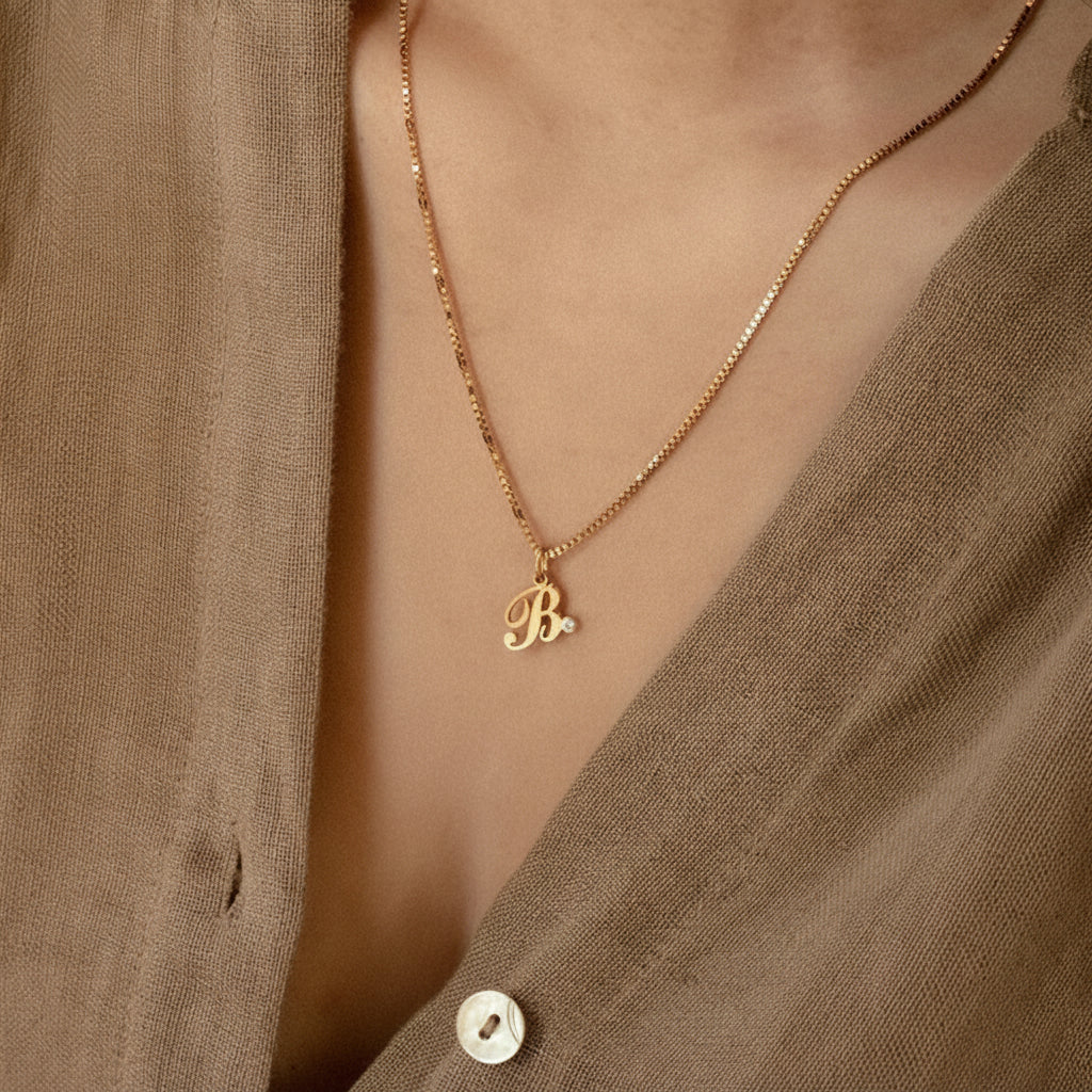 Gold stainless steel personalized letter necklace with birthstone accent on a link chain, elegant charm jewelry for women.