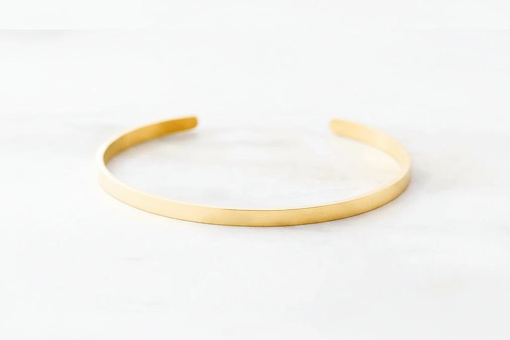 Minimalist 316L stainless steel engraved bar cuff bracelet with custom lettering, 4mm width, gold finish shown.