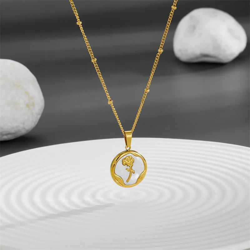 Gold PVD plated stainless steel necklace with round zircon flower pendant, minimalist floral design displayed on chain.
